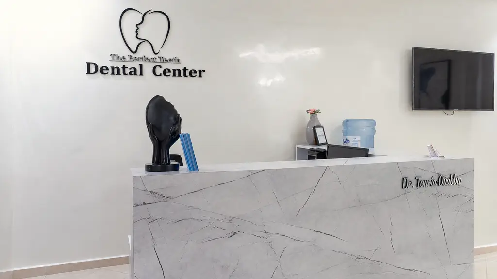 L’accueil du cabinet, avec le logo The Perfect Teeth Dental Center au mur