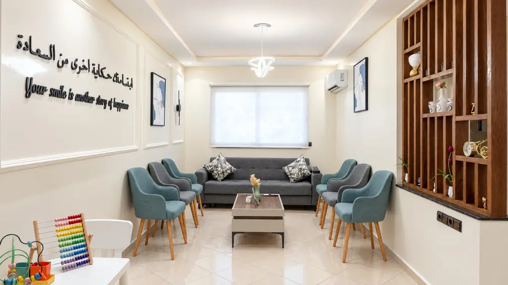 La salle d’attente, ses fauteuils bleus et la citation « Your smile is another story of happiness » au mur
